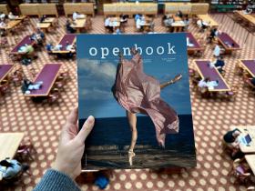 Photograph of a hand holding a magazine called Openbook