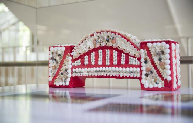 A small red bridge covered by white shells