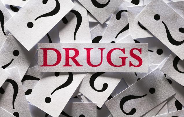Pile of cards with question marks on them and the word drugs in the middle