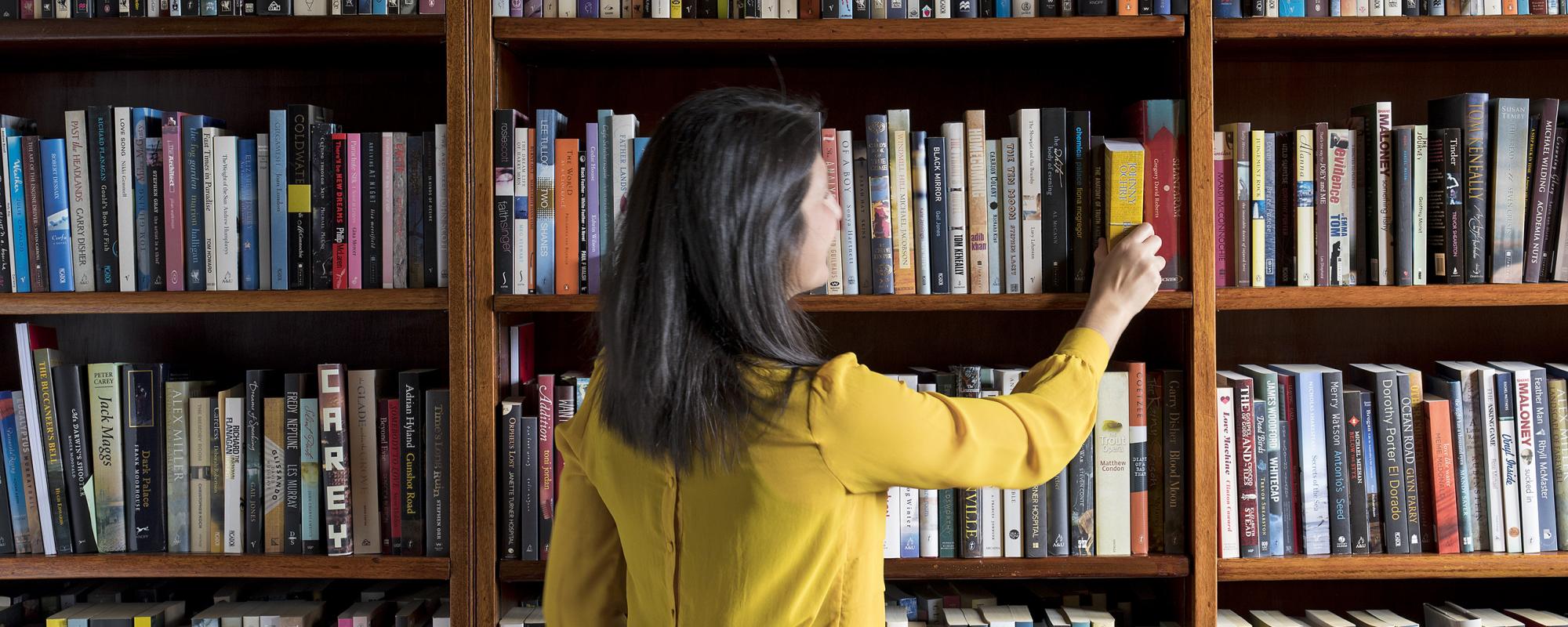 Women pulling books off shelf