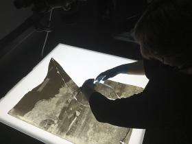 Person from the Library's Collection Care reassembling the shattered Holtermann wet-plate glass negative for digitisation. 