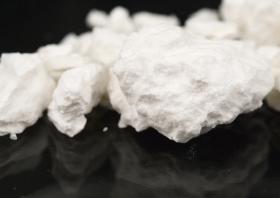 Close up photo of cocaine rocks on black background.
