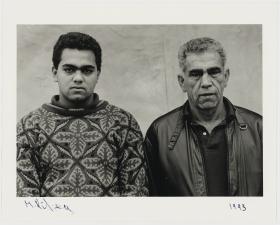 A black and white photograph of two men standing side by side looking at the camera.