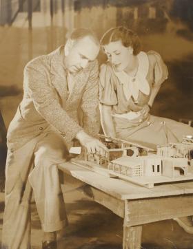 Man and woman looking at miniature house on a table