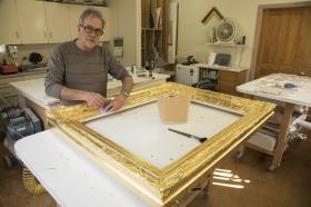 David Butler prepares a new frame for the painting 