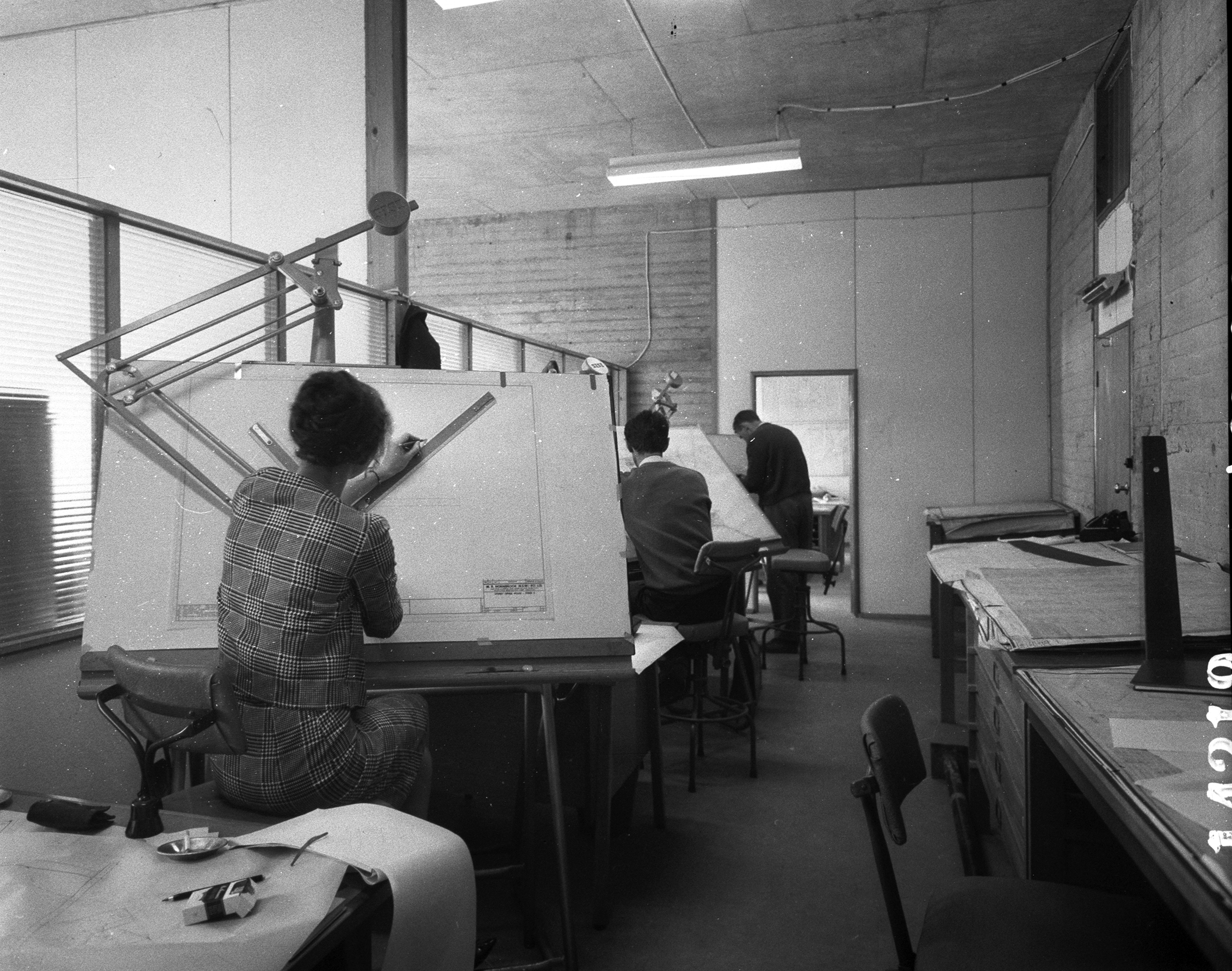 A black and white photograph of architects working at drafting tables in 1963