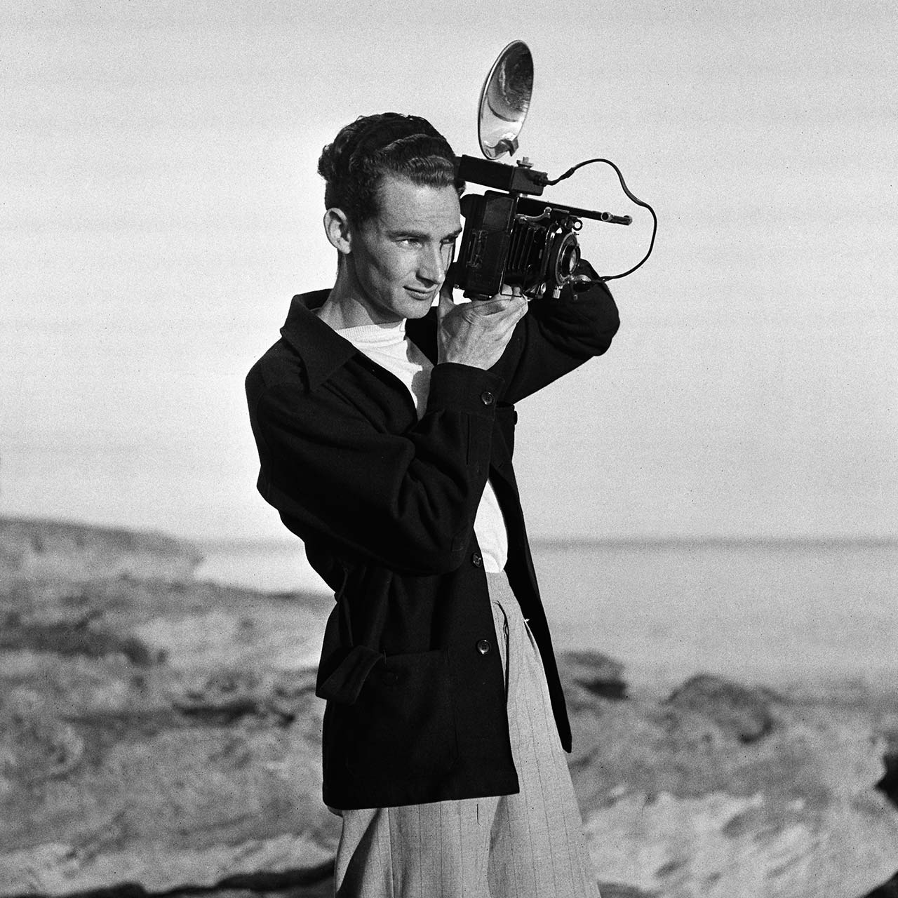 George with Voigtländer Bergheil camera, with roll film back and flashgun, 30 June 1940. (Digital ID: a2391049)