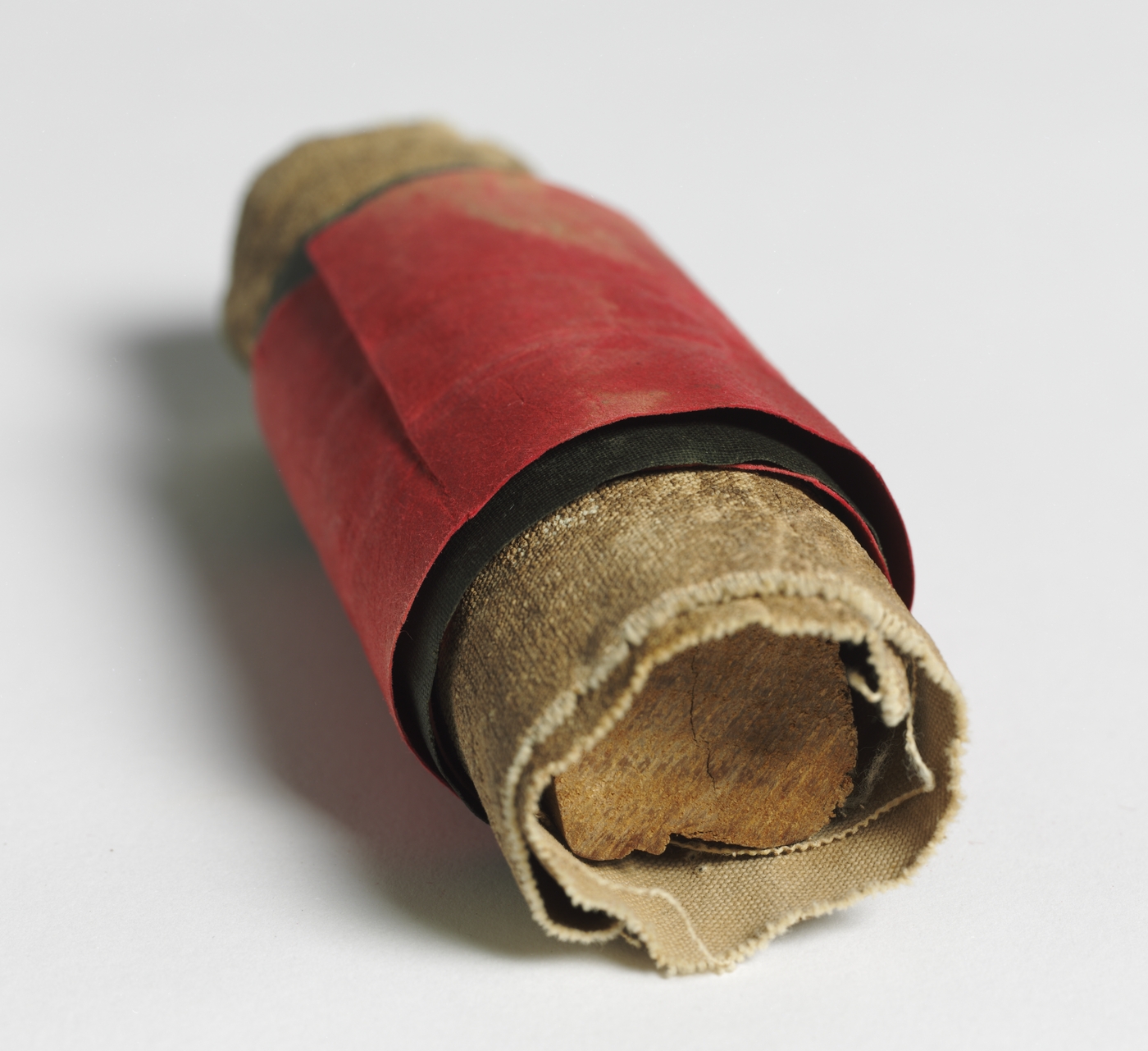 Strips of thick-looking fabric, wound around a cylindrical piece of wood.