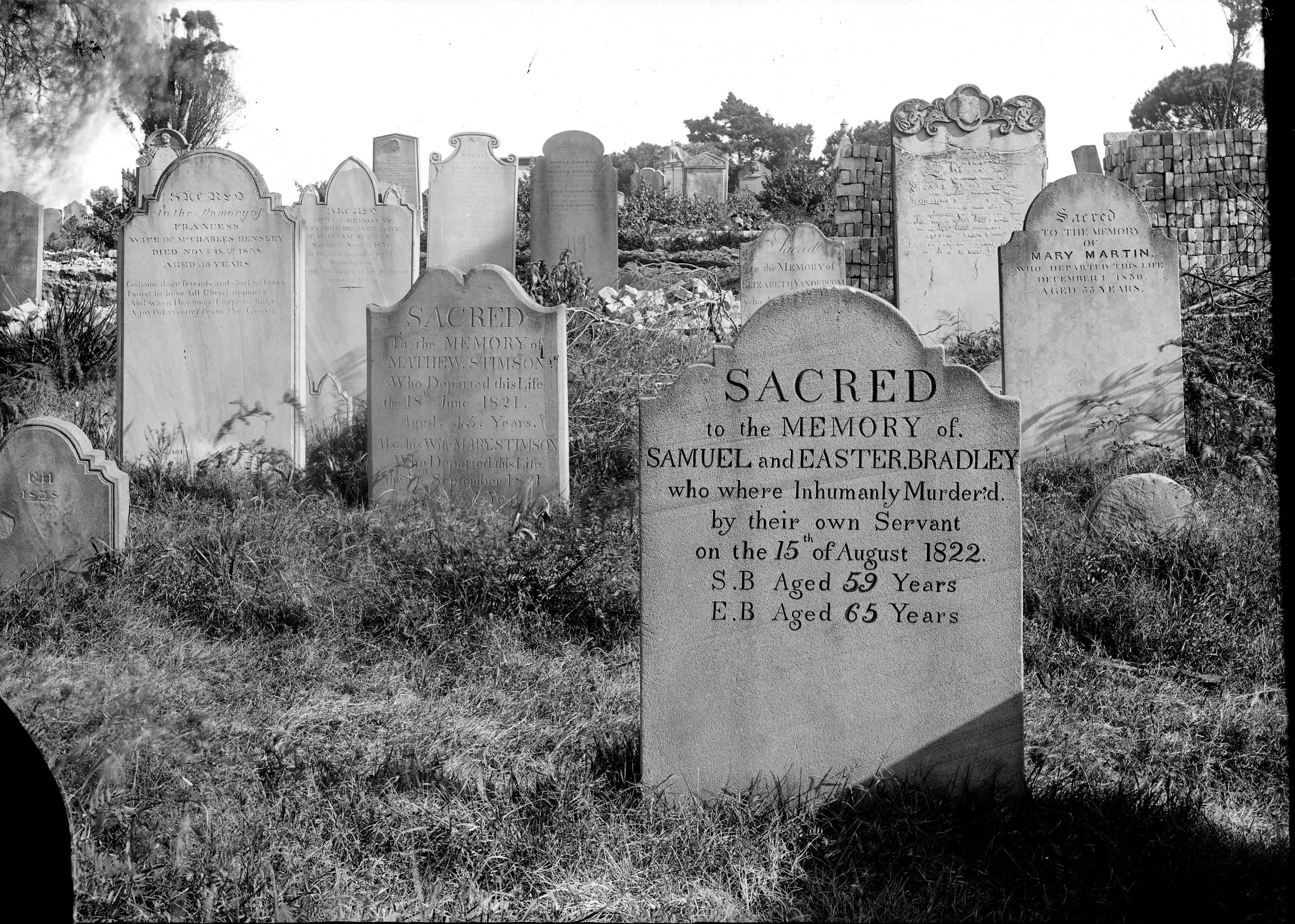A black and white photograph of a graveyard. The headstone of Samuel and Easter Bradley in the foreground. 