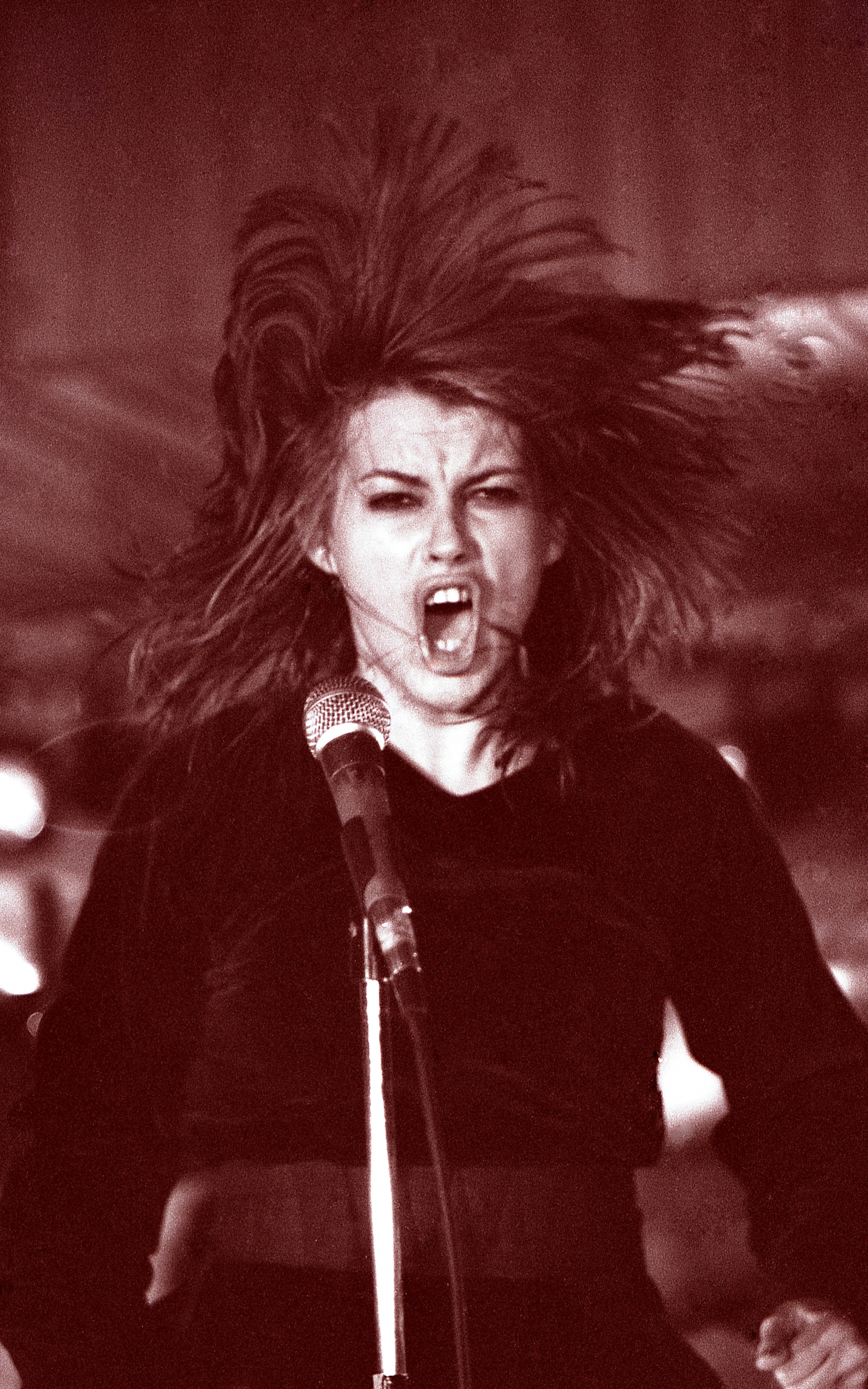 Chrissy Amphlett's hair sounds her head like a mane as she performs live.
