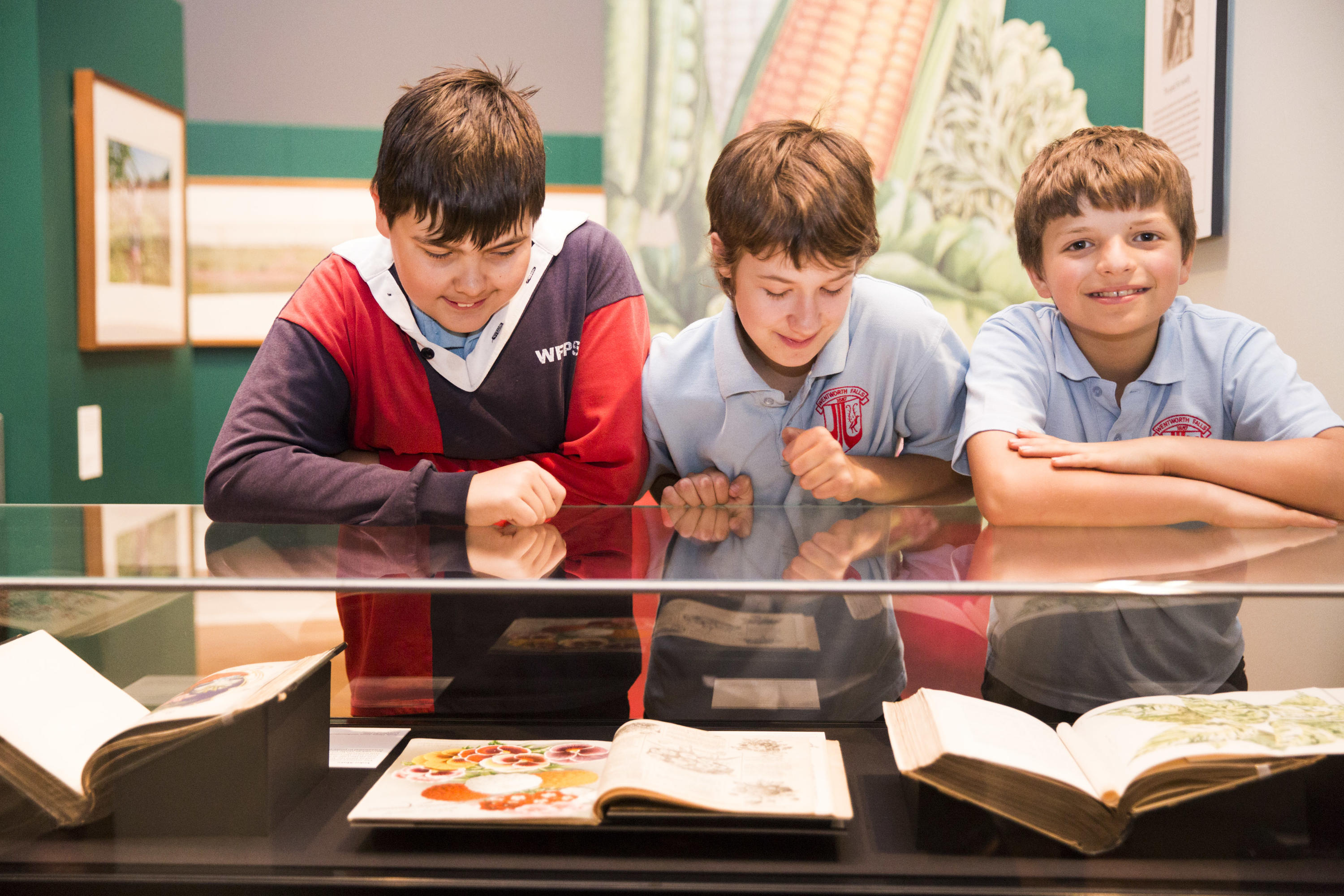 3 students looking into a showcase in an exhibition