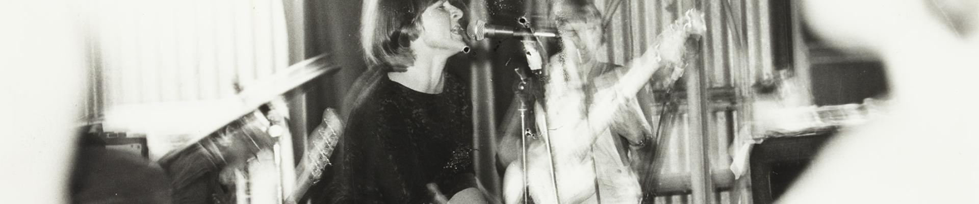 A black and white photo of a singer in a band, with a shaky effect.