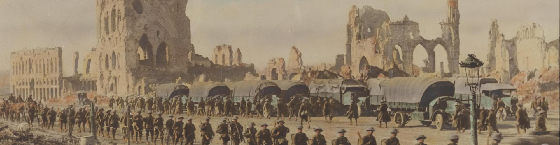 A hand coloured photograph of soldiers filing past the ruins of grand buildings.