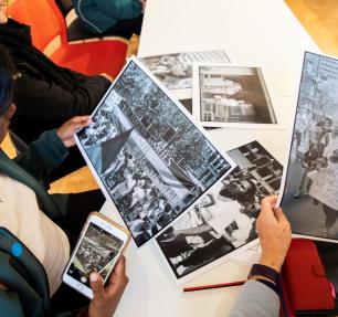 People holding photographs at a table