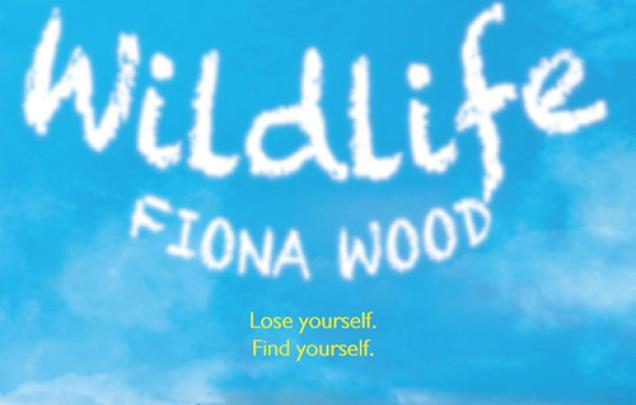 Two sets of legs with shoes lying on a grass on book cover of Wildlife by Fiona Wood
