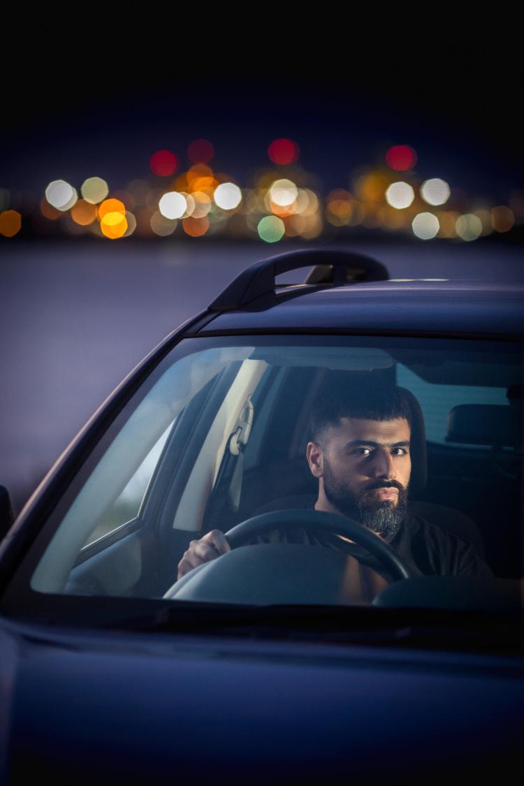 Portrait of George Haddad sitting in a car at night.