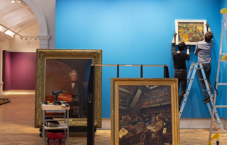 Curators placing paintings on gallery wall