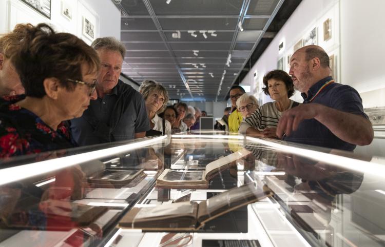 Tour guide showing objects in a glass box