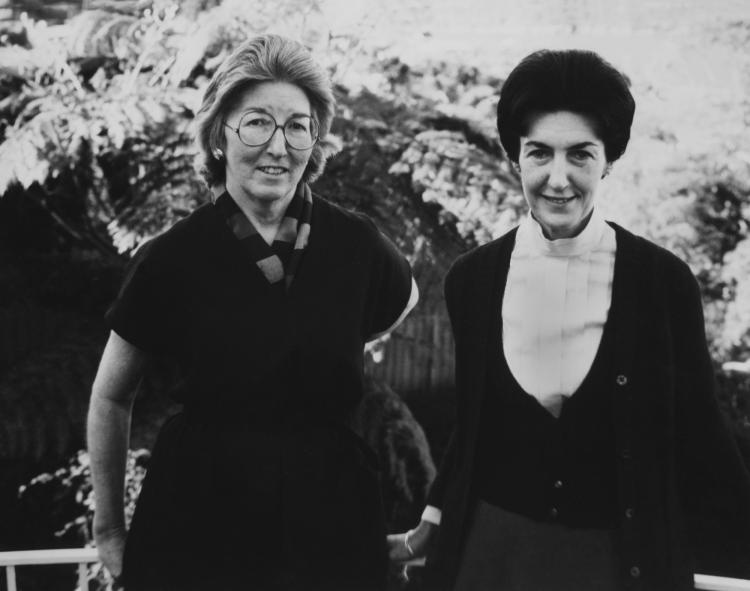 Two women stand together in black and white photo