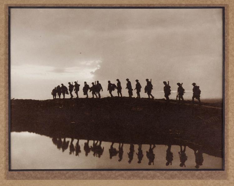 Men in silhouette walking along duckboards in the western front, 1917.