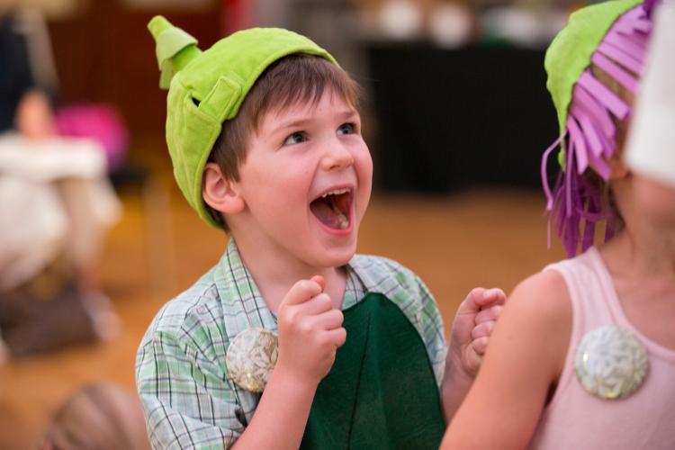 Excited young boy wearing green hat