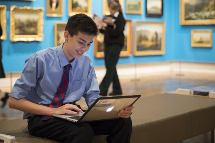 Boy uses laptop in gallery