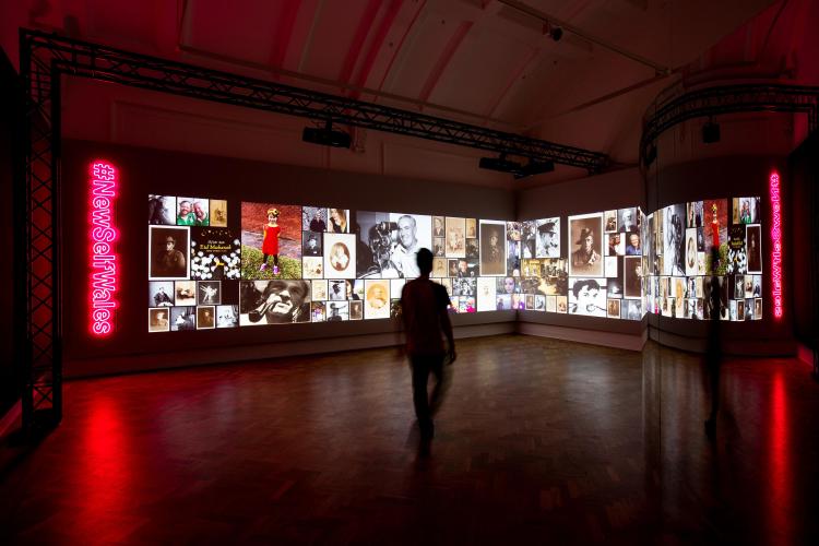 Projections of a grid of portraits projected onto a gallery's walls. 