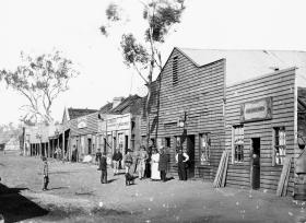 A black and white photograph of an 1800s main street.