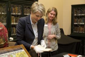 Woman looking at old diaries with gloves on