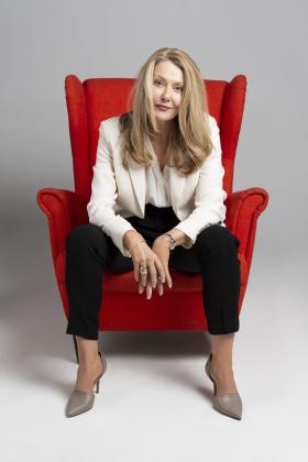 Anna Funder sits in red chair