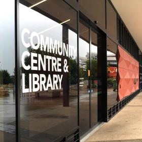 External view of a library with sign on windows