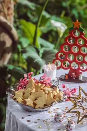Table with a bowl of shortbread cookies and Christmas decorations.