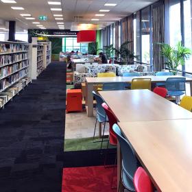 Long view of library bookshelves, tables and chairs