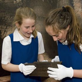 Two students looking at wooden object
