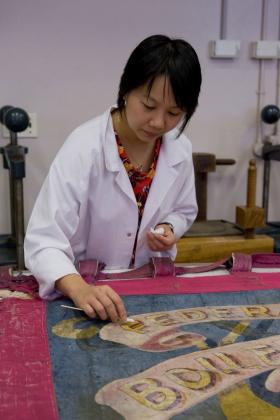 Woman removing mould from silk banner