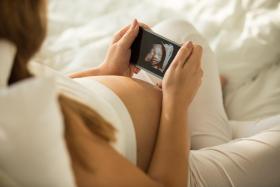 Pregnant woman looking at sonogram picture