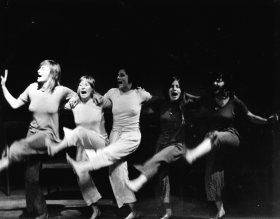 Black and white photograph of five women on stage.