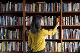 Women pulling books off shelf