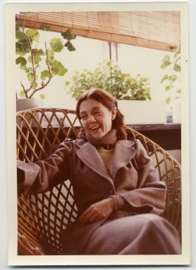 Colour photograph of a woman sitting in a chair.