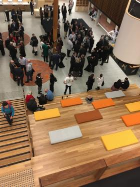 Stairs and stair seating with a large number of people standing in an open area.