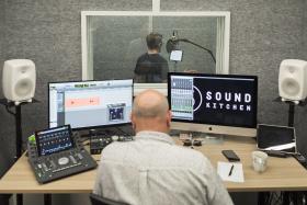 Ben Crabbe, sitting at the controls, produces James Sweeny reading in the sound booth. Photo by Joy Lai