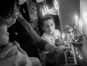 black and white image of the Slavin family lighting candles for Hanukkahh