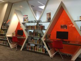 Children's area in library bookshelves and PCs