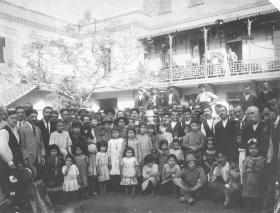 A group of 60 to 70 people in front of a building, with mostly children in the foreground.
