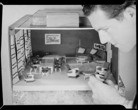 Man playing with dollhouse