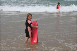 Boy in water with surfboard