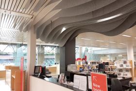 A library service counter, with wave-shaped acoustic features on the ceiling.