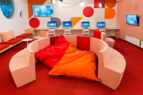 Room with brightly coloured modular furniture and computers at a desk