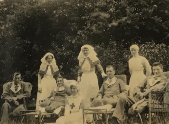 Patients Hushesman, Thompson, Trainer and Shaw recuperate in the grounds at the North Evington military hospital in Leicester, England with Sister Baldwin and VADs, c.1916 