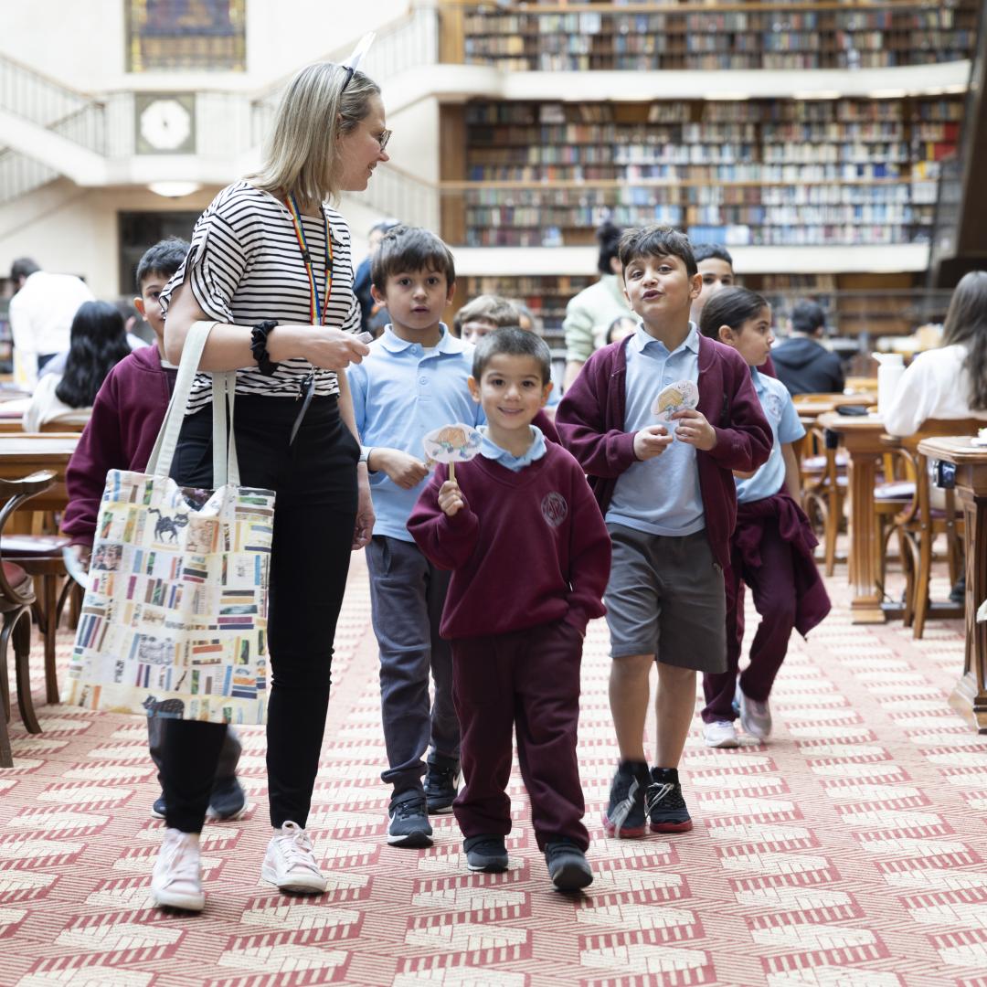 A person walking with children in a library
